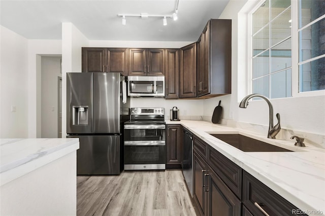 18633 Stroh Rd Unit 2-206, Parker, CO 80134 - kitchen featuring a sink, light stone counters, light wood finished floors, dark brown cabinets, and appliances with stainless steel finishes