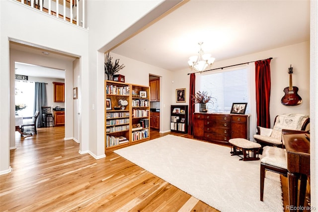 living area with light wood-type flooring and a notable chandelier