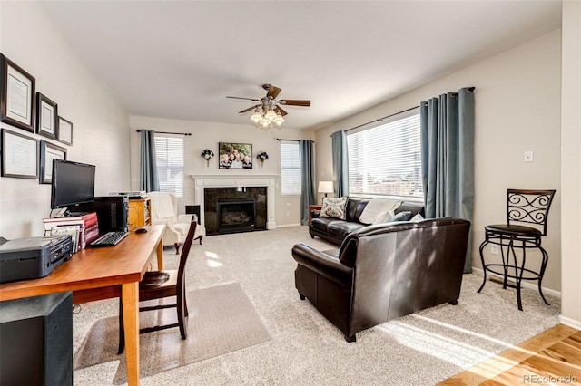 living room featuring ceiling fan, a high end fireplace, and carpet flooring