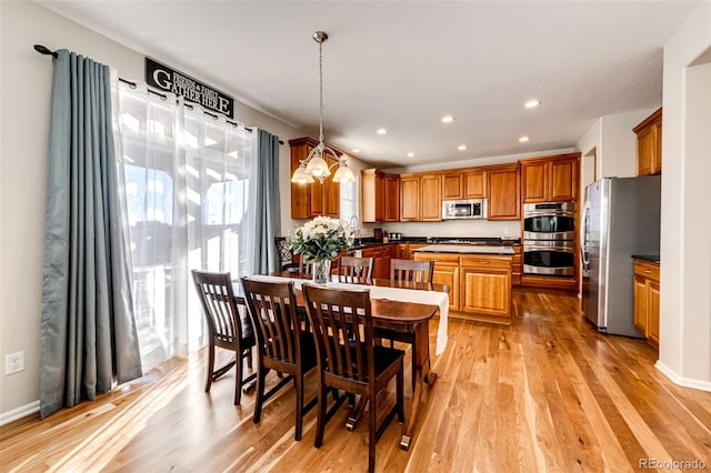 dining room with a chandelier, light hardwood / wood-style flooring, and sink