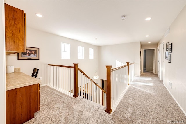 hallway featuring light colored carpet