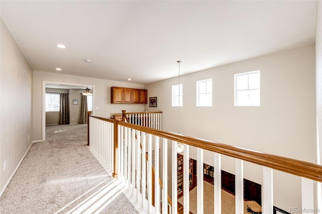 hall with light colored carpet