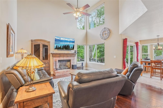 16071 Crestrock Cir, Parker, CO 80134 - living area with a towering ceiling, plenty of natural light, a ceiling fan, hardwood / wood-style flooring, and a fireplace