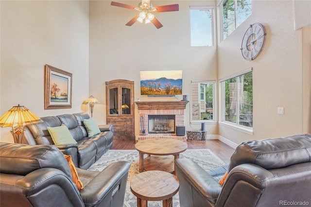 16071 Crestrock Cir, Parker, CO 80134 - living area featuring a towering ceiling, ceiling fan, wood finished floors, and a brick fireplace