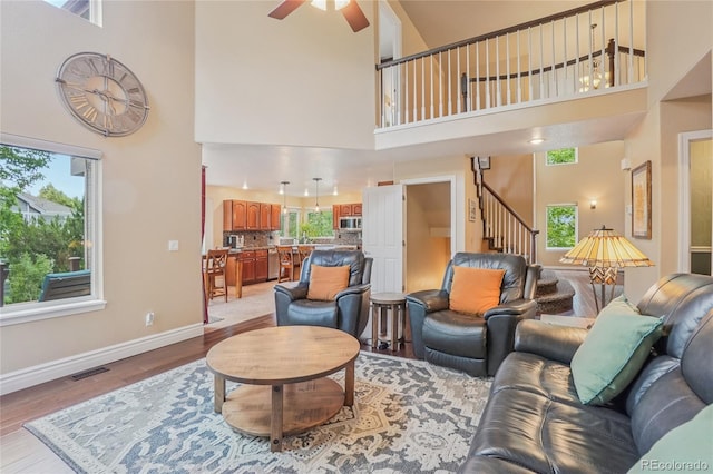 16071 Crestrock Cir, Parker, CO 80134 - living room with a high ceiling, a ceiling fan, stairway, and light wood-style floors