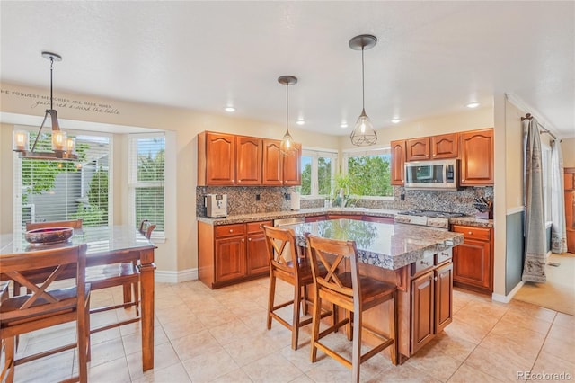 16071 Crestrock Cir, Parker, CO 80134 - kitchen featuring stainless steel microwave, brown cabinetry, light tile patterned flooring, tasteful backsplash, and recessed lighting