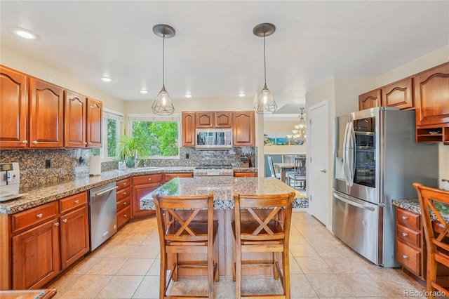 16071 Crestrock Cir, Parker, CO 80134 - kitchen with stainless steel appliances, backsplash, a center island, light tile patterned flooring, and light stone counters