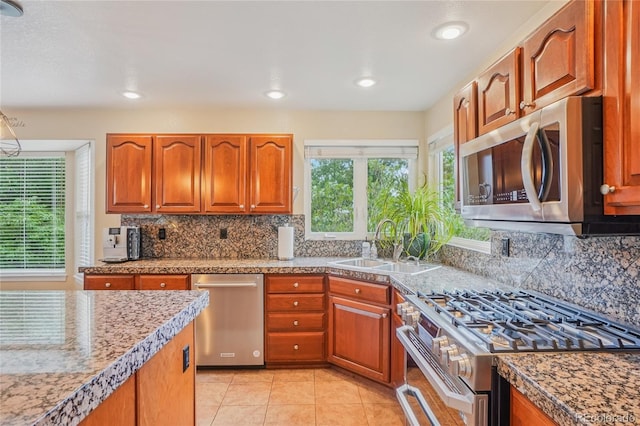16071 Crestrock Cir, Parker, CO 80134 - kitchen featuring appliances with stainless steel finishes, brown cabinetry, backsplash, light tile patterned floors, and recessed lighting