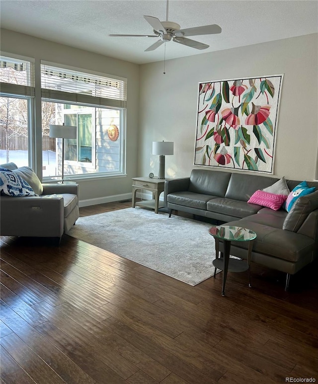 living room featuring ceiling fan, dark hardwood / wood-style floors, and a textured ceiling