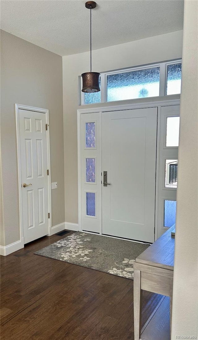 foyer featuring dark hardwood / wood-style floors and a textured ceiling