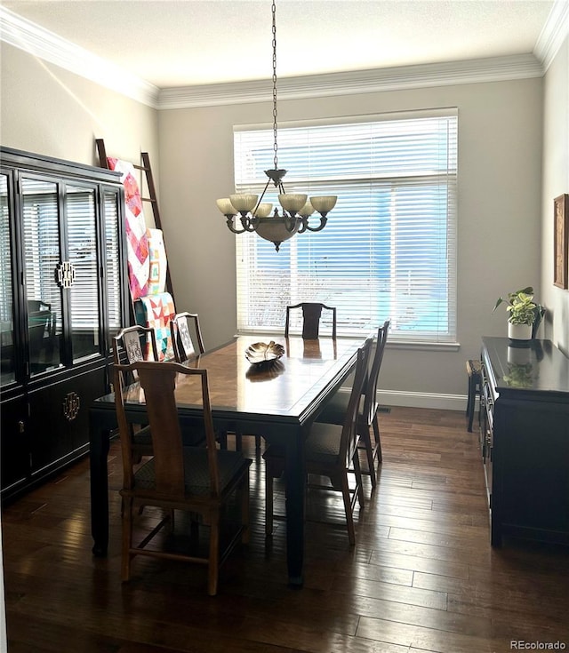 dining area with dark wood-type flooring, ornamental molding, and a chandelier