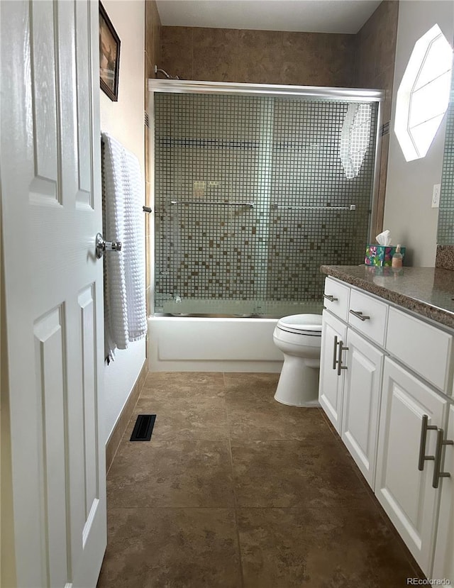 full bathroom featuring vanity, toilet, and combined bath / shower with glass door