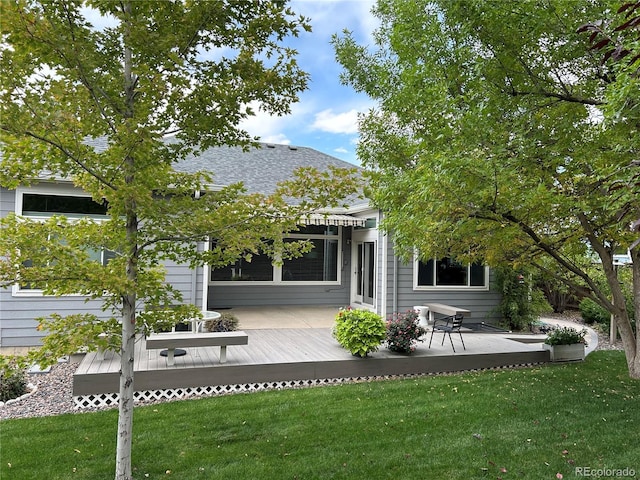 back of property with a wooden deck, a pergola, and a lawn