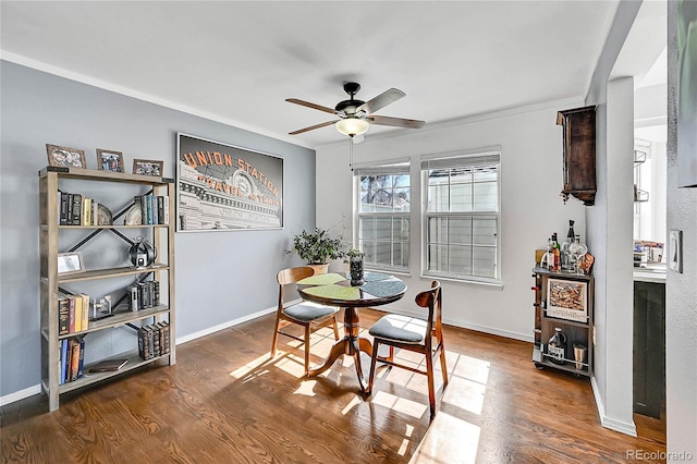 dining space featuring ceiling fan, baseboards, and wood finished floors