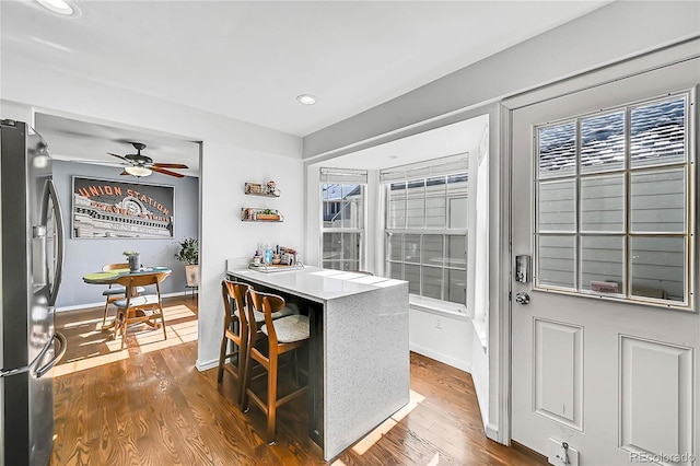 dining room with a ceiling fan, baseboards, and wood finished floors