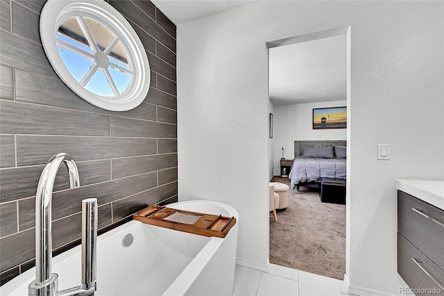 bathroom featuring a soaking tub, vanity, ensuite bath, and tile patterned floors