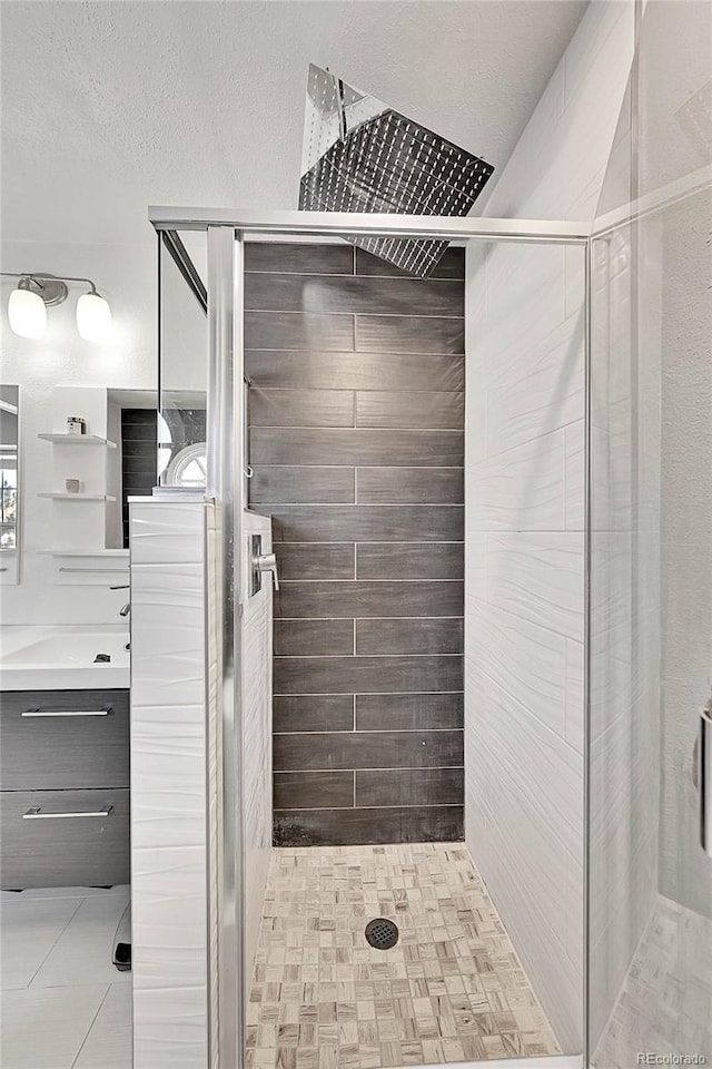 bathroom featuring a stall shower and a textured ceiling