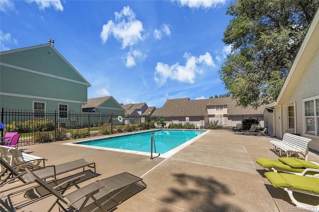 pool with a residential view, fence, and a patio