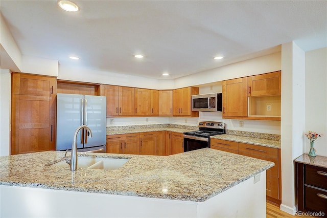 8754 Mesquite Row, Lone Tree, CO 80124 - kitchen with stainless steel appliances, recessed lighting, light stone counters, and brown cabinets