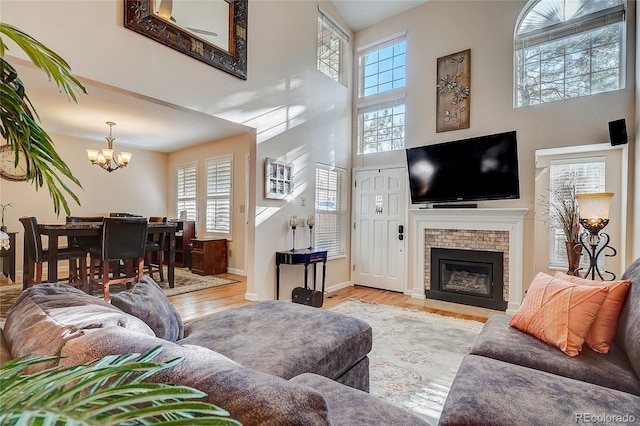 8754 Mesquite Row, Lone Tree, CO 80124 - living room featuring a chandelier, healthy amount of natural light, a high ceiling, wood finished floors, and a brick fireplace