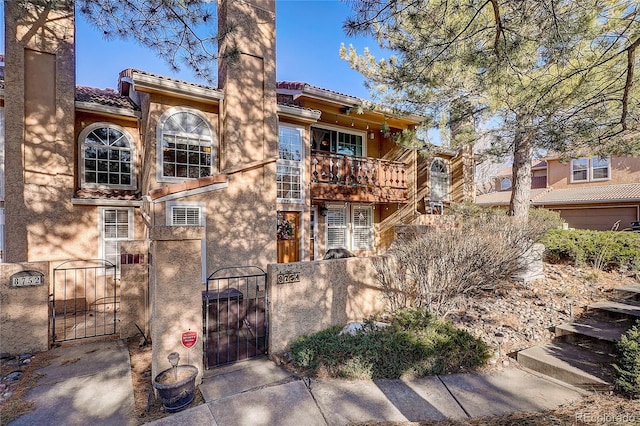 8754 Mesquite Row, Lone Tree, CO 80124 - rear view of house with a gate, a balcony, a tiled roof, and stucco siding