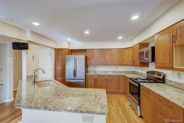8754 Mesquite Row, Lone Tree, CO 80124 - kitchen with appliances with stainless steel finishes, light wood-style flooring, light stone counters, brown cabinetry, and recessed lighting