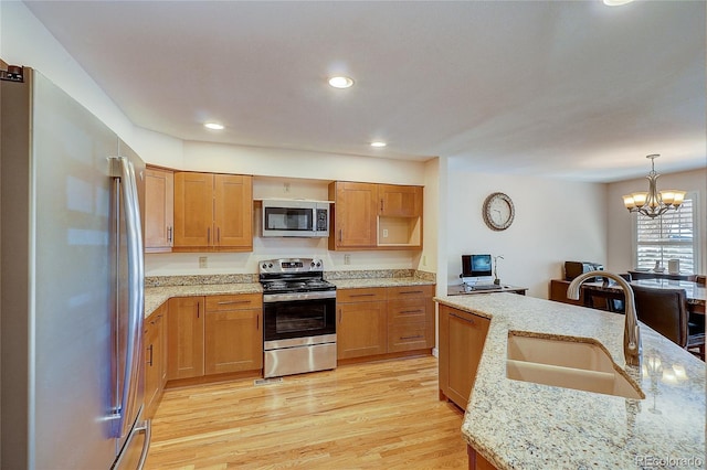 8754 Mesquite Row, Lone Tree, CO 80124 - kitchen featuring stainless steel appliances, light wood finished floors, recessed lighting, a chandelier, and light stone counters