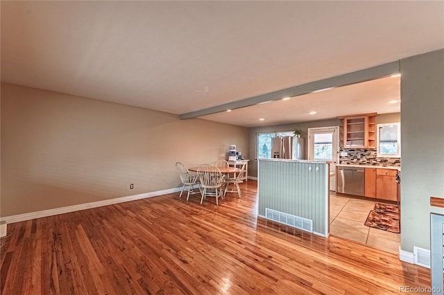 kitchen featuring light wood-style floors, baseboards, open shelves, and stainless steel appliances