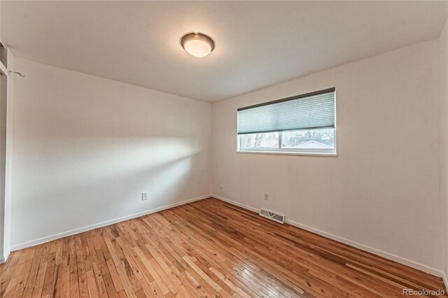 unfurnished room featuring visible vents, baseboards, and light wood-style flooring