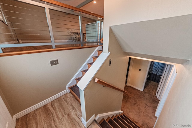 staircase featuring baseboards and wood finished floors