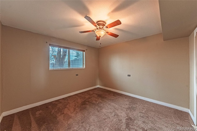 carpeted spare room with baseboards and a ceiling fan