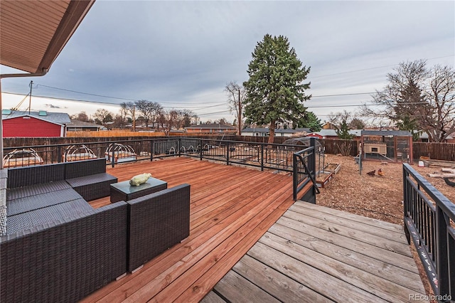 wooden terrace featuring an outdoor living space and a fenced backyard