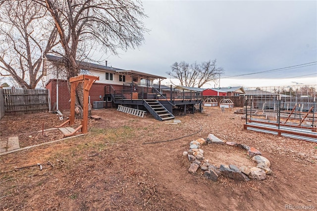 view of yard featuring a fenced backyard, a wooden deck, stairway, and central AC
