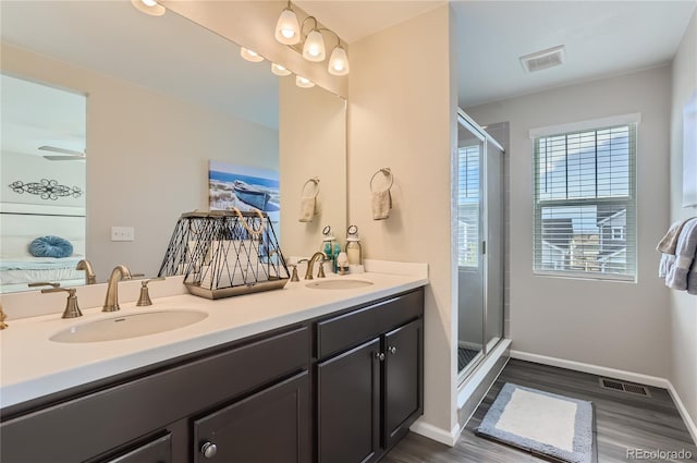 bathroom featuring a shower with door, vanity, ceiling fan, and hardwood / wood-style flooring