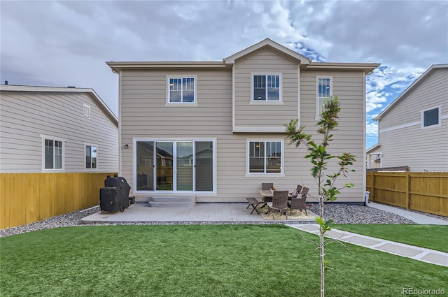 rear view of property with a yard and a patio area