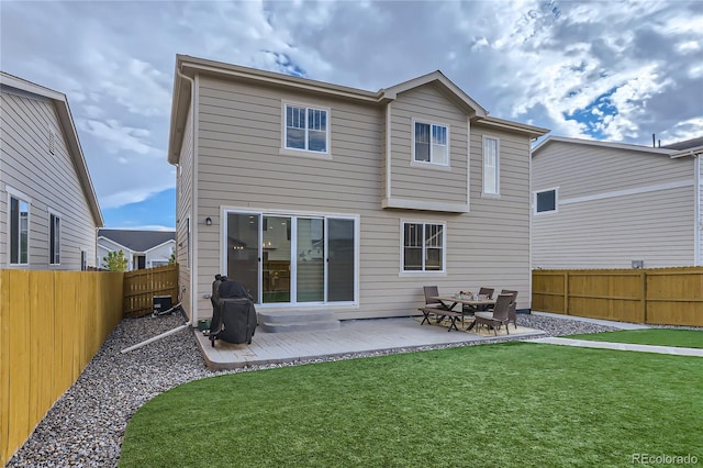 rear view of property featuring a lawn, central AC unit, and a patio