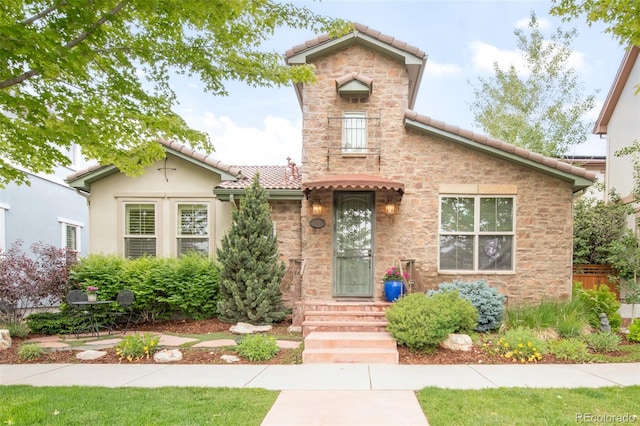 3143 Elmira St, Denver, CO 80238 - view of front of property with a tile roof, stone siding, entry steps, and stucco siding