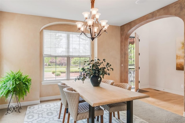 3143 Elmira St, Denver, CO 80238 - dining room featuring arched walkways, plenty of natural light, a chandelier, and baseboards