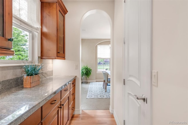 3143 Elmira St, Denver, CO 80238 - hallway featuring arched walkways, baseboards, and light wood-style floors