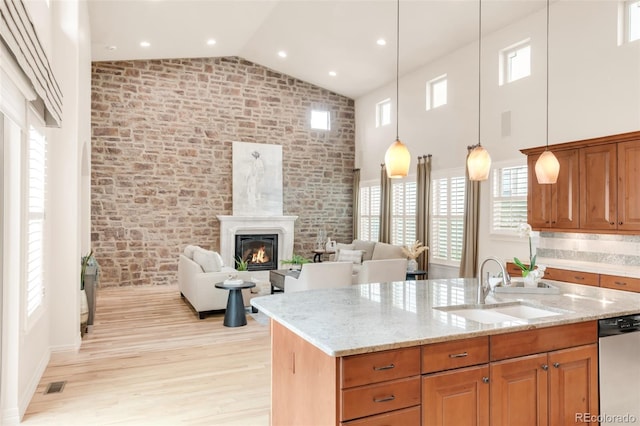3143 Elmira St, Denver, CO 80238 - kitchen featuring stainless steel dishwasher, high vaulted ceiling, brick wall, a sink, and light wood-style floors