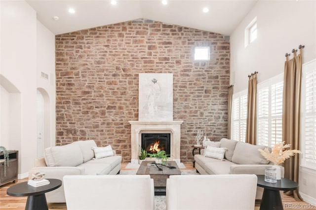 3143 Elmira St, Denver, CO 80238 - living area featuring high vaulted ceiling, a high end fireplace, wood finished floors, and plenty of natural light