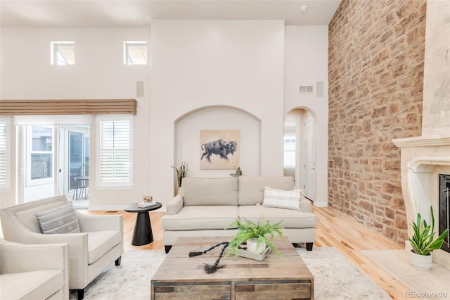 3143 Elmira St, Denver, CO 80238 - living room with wood finished floors, healthy amount of natural light, a towering ceiling, a fireplace with flush hearth, and arched walkways