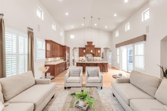 3143 Elmira St, Denver, CO 80238 - living area with arched walkways, a high ceiling, recessed lighting, light wood finished floors, and plenty of natural light