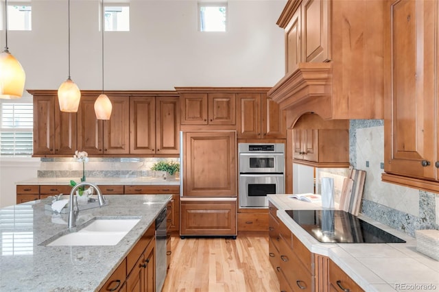 3143 Elmira St, Denver, CO 80238 - kitchen featuring black electric cooktop, paneled built in fridge, a sink, stainless steel double oven, and brown cabinetry