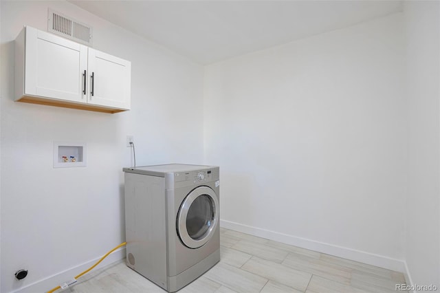 washroom featuring cabinets and washer / clothes dryer