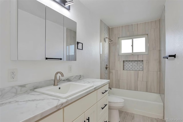 full bathroom featuring toilet, vanity, hardwood / wood-style floors, and tiled shower / bath