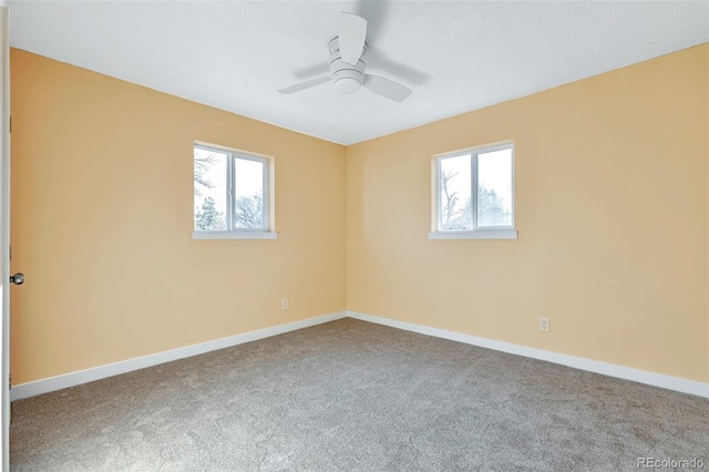 carpeted spare room with plenty of natural light and ceiling fan