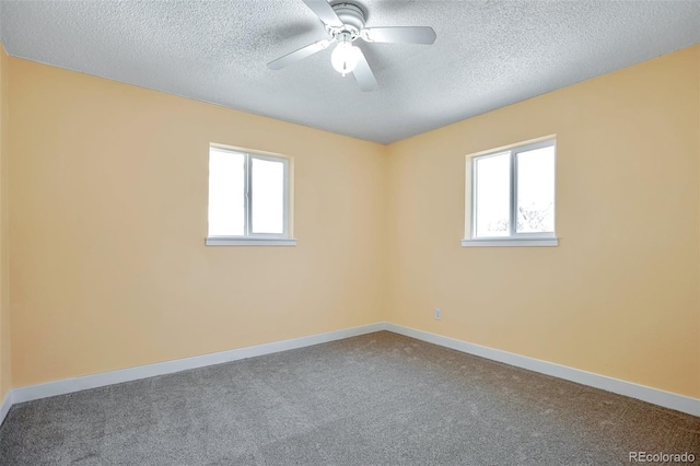 carpeted spare room featuring ceiling fan and a textured ceiling