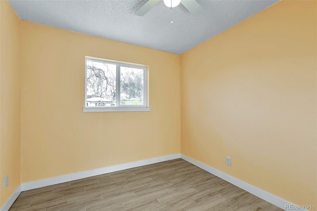 unfurnished room featuring ceiling fan, light hardwood / wood-style floors, and a textured ceiling