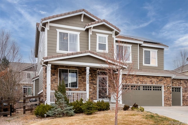 craftsman inspired home with a porch, a garage, stone siding, a tiled roof, and driveway